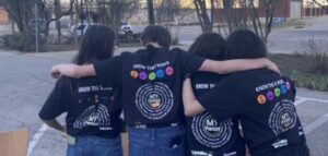 Students at YWLA posing to show off backs of their junior high TDS shirts